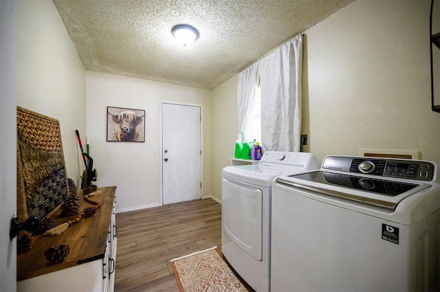 308 E Highland St, Hugo, OK 74743 - clothes washing area featuring washing machine and clothes dryer, a textured ceiling, light wood-style flooring, and baseboards