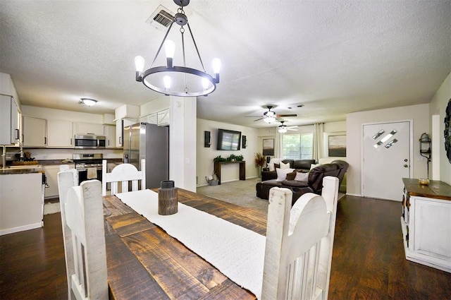308 E Highland St, Hugo, OK 74743 - dining space featuring a chandelier, a textured ceiling, ceiling fan, and dark wood-style floors
