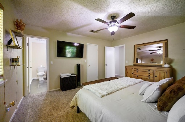 308 E Highland St, Hugo, OK 74743 - carpeted bedroom featuring a textured ceiling, connected bathroom, a ceiling fan, and baseboards