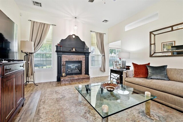 3005 Summit Hill Rd, Norman, OK 73071 - living area featuring light wood finished floors, a brick fireplace, baseboards, and ceiling fan