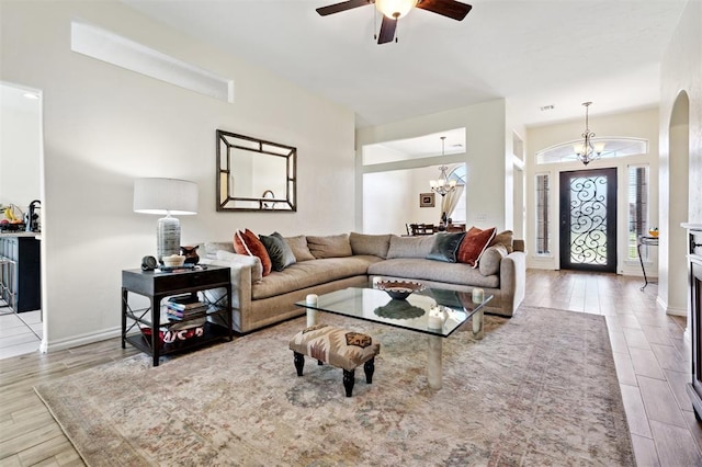 3005 Summit Hill Rd, Norman, OK 73071 - living room with a chandelier, ceiling fan, wood finished floors, baseboards, and arched walkways