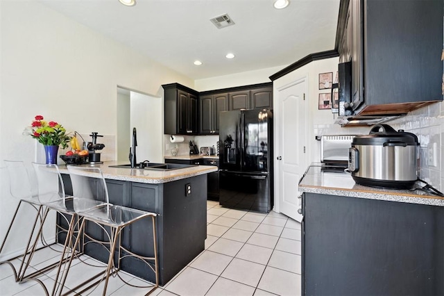 3005 Summit Hill Rd, Norman, OK 73071 - kitchen featuring black appliances, a sink, a peninsula, a breakfast bar area, and light countertops