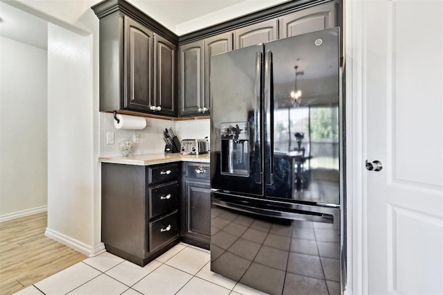 3005 Summit Hill Rd, Norman, OK 73071 - kitchen with black refrigerator with ice dispenser, baseboards, and light tile patterned floors