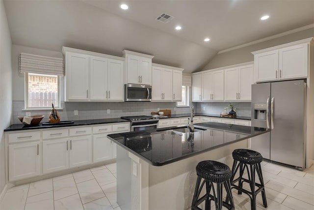 6812 NW 149th St, Oklahoma City, OK 73142 - kitchen with appliances with stainless steel finishes, white cabinets, an island with sink, tasteful backsplash, and lofted ceiling