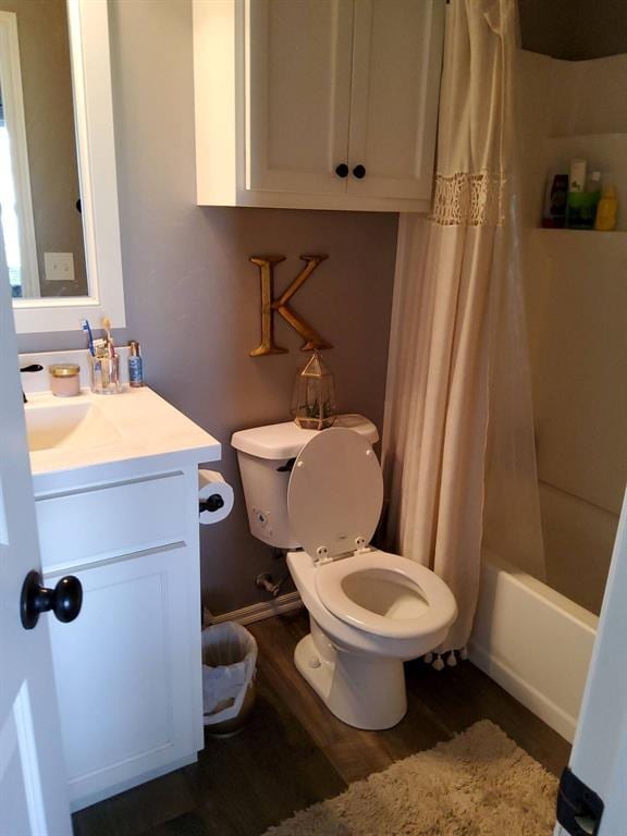 full bath featuring wood finished floors, toilet, vanity, and shower / bathtub combination with curtain
