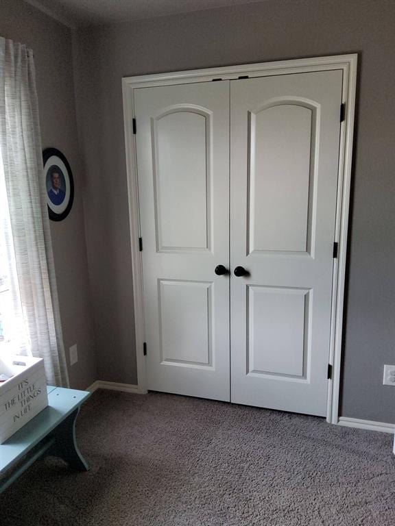 unfurnished bedroom with carpet, baseboards, and a closet