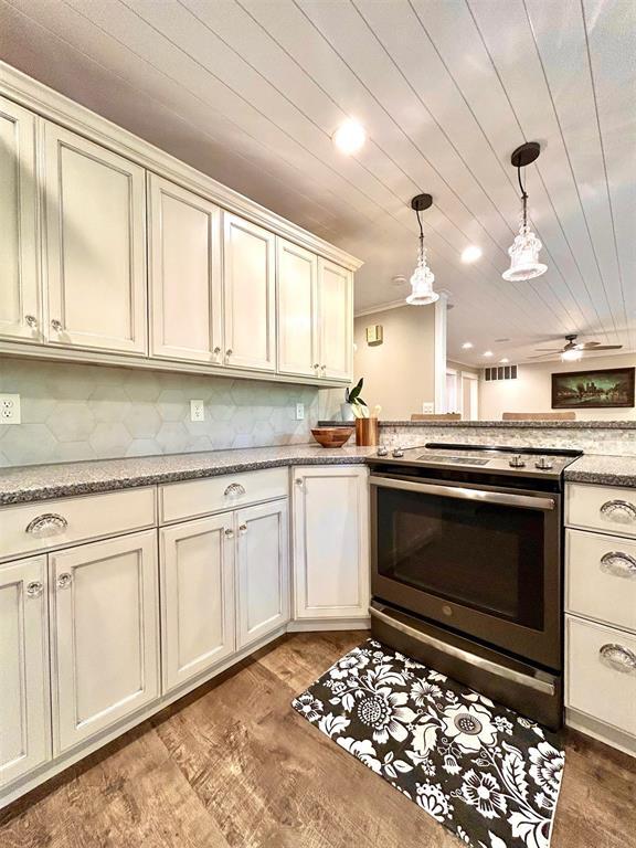 4008 Creekwood, Edmond, OK 73025 - kitchen with stainless steel range with electric cooktop, hanging light fixtures, wood finished floors, backsplash, and wooden ceiling