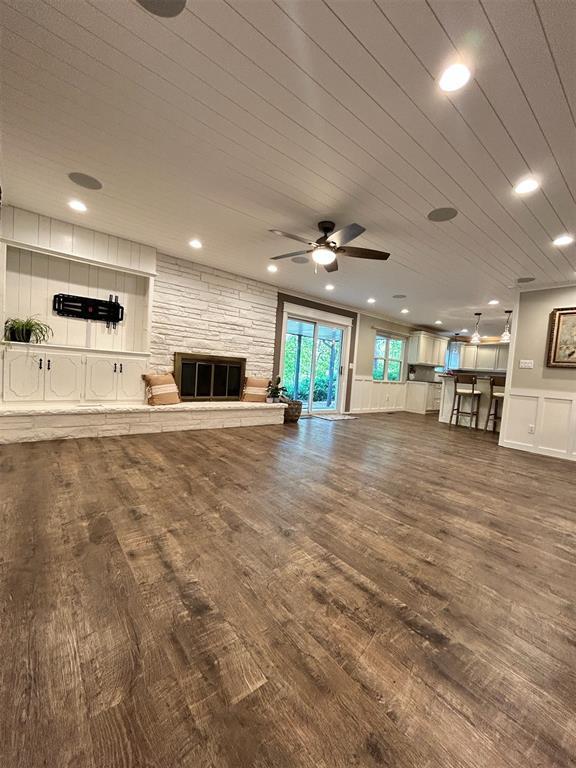 4008 Creekwood, Edmond, OK 73025 - unfurnished living room featuring a stone fireplace, ceiling fan, wood finished floors, and recessed lighting