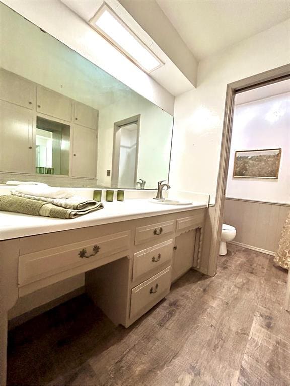 4008 Creekwood, Edmond, OK 73025 - bathroom with wood finished floors, toilet, wainscoting, and vanity