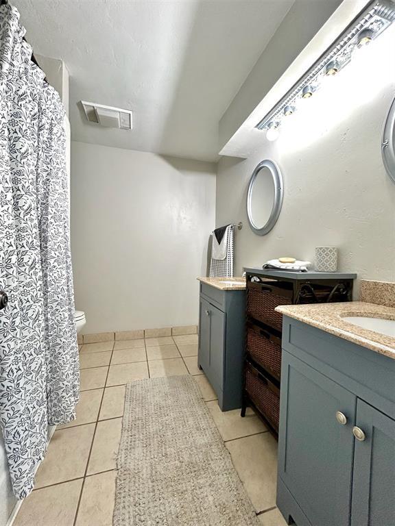 4008 Creekwood, Edmond, OK 73025 - bathroom with tile patterned floors, two vanities, and a shower with curtain