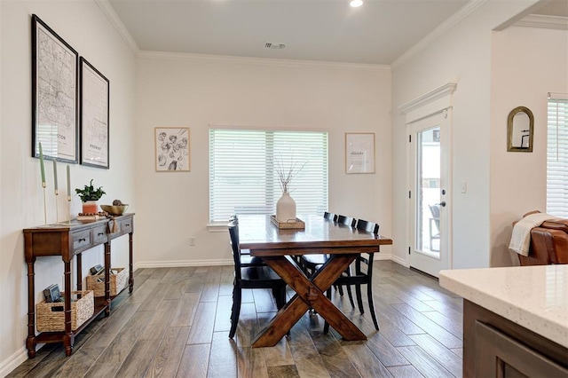 dining area with healthy amount of natural light, dark wood finished floors, ornamental molding, and baseboards