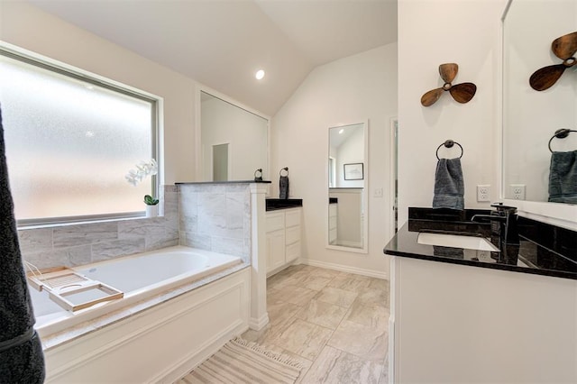 bathroom with marble finish floors, lofted ceiling, a garden tub, two vanities, and recessed lighting