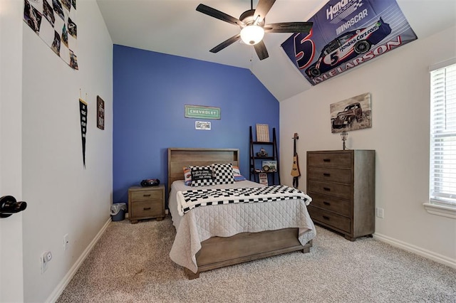 carpeted bedroom featuring baseboards, multiple windows, vaulted ceiling, and a ceiling fan