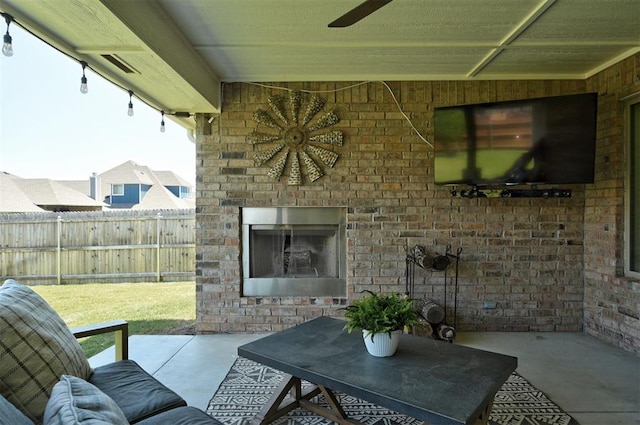 view of patio / terrace featuring an outdoor brick fireplace, ceiling fan, and fence