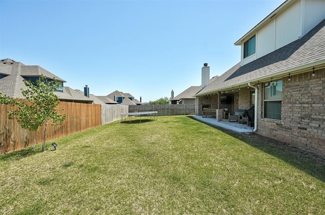 view of yard featuring a trampoline and a patio area