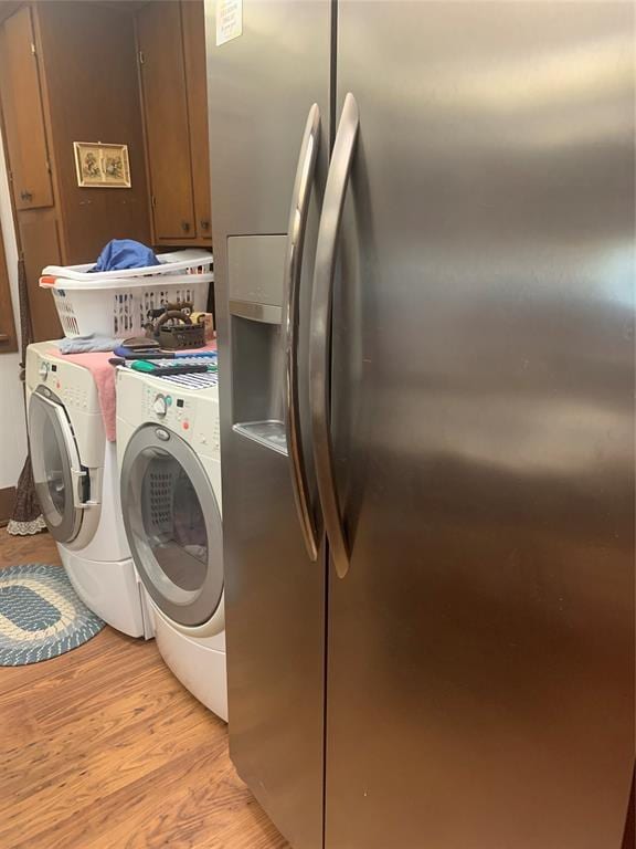 845 N Washington Ave, Mountain View, OK 73062 - laundry room with light wood-style flooring, cabinet space, and washer and clothes dryer