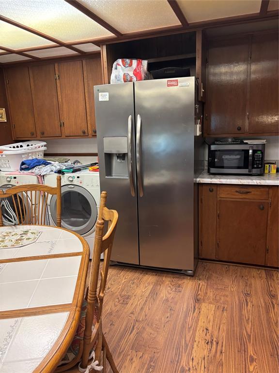 845 N Washington Ave, Mountain View, OK 73062 - kitchen featuring stainless steel appliances, light countertops, light wood-type flooring, and brown cabinets