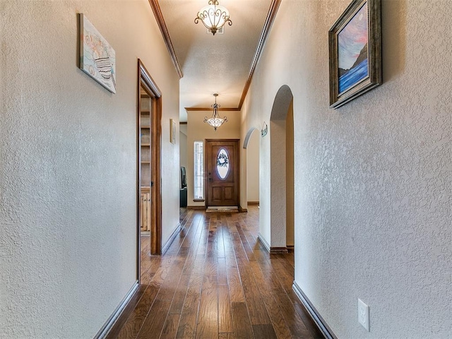 4105 Nailon Dr, Norman, OK 73072 - doorway to outside featuring ornamental molding, a textured wall, arched walkways, dark wood-style floors, and baseboards