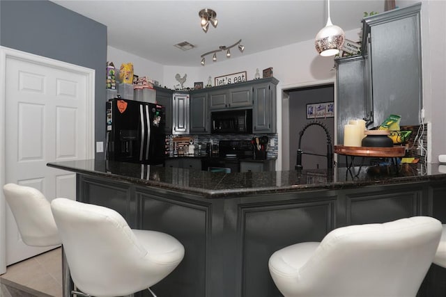 717 Vickery Ave, Yukon, OK 73099 - kitchen with black appliances, a sink, a peninsula, decorative backsplash, and dark stone countertops