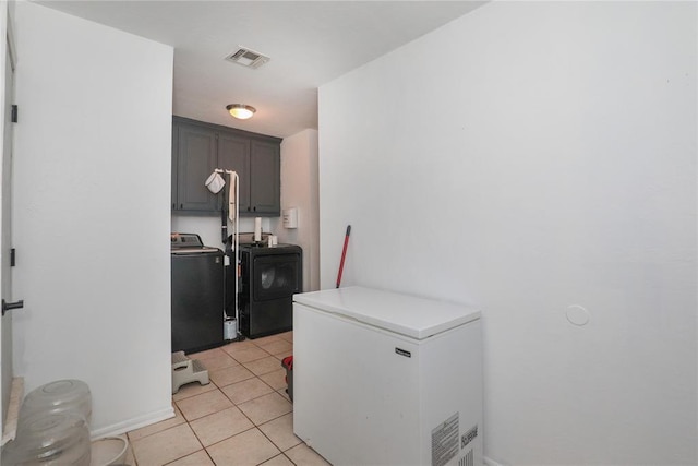 717 Vickery Ave, Yukon, OK 73099 - laundry area featuring cabinet space, washing machine and dryer, and light tile patterned floors