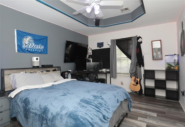 717 Vickery Ave, Yukon, OK 73099 - bedroom with wood finished floors, a tray ceiling, and ceiling fan