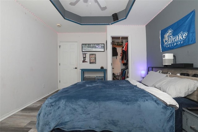 717 Vickery Ave, Yukon, OK 73099 - bedroom with wood finished floors, a walk in closet, baseboards, a ceiling fan, and a closet