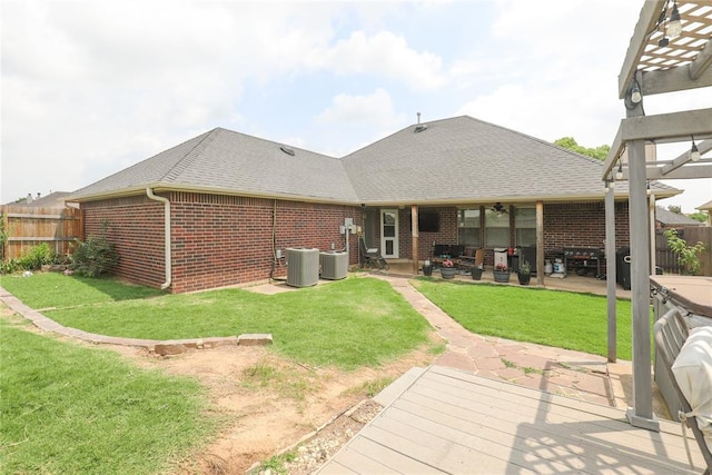 717 Vickery Ave, Yukon, OK 73099 - back of property featuring brick siding, a patio, roof with shingles, and central AC