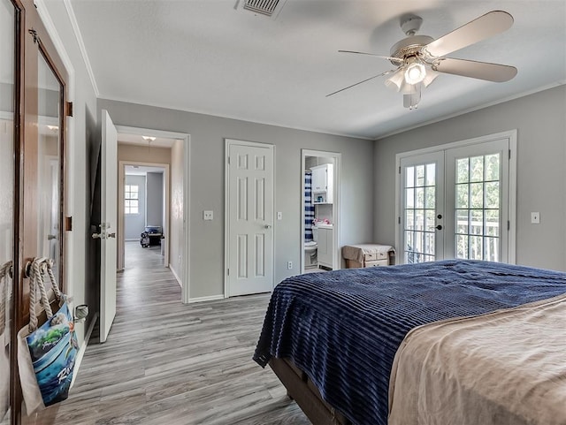 2101 NE 11th St, Moore, OK 73160 - bedroom with french doors, multiple windows, light wood finished floors, access to outside, and ornamental molding