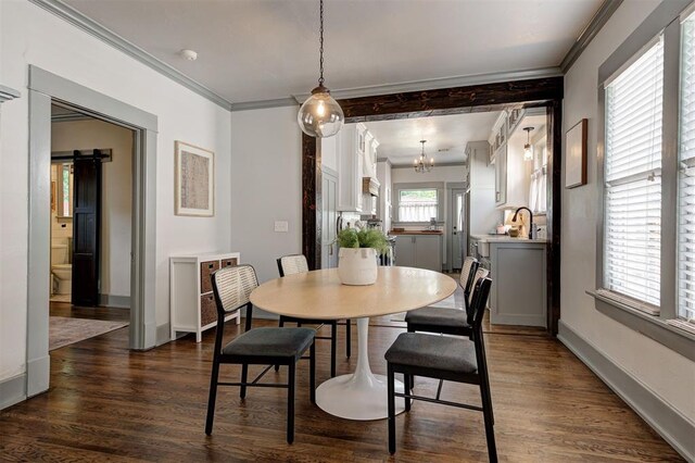 704 NW 20th St, Oklahoma City, OK 73103 - dining space featuring a chandelier, dark wood-type flooring, crown molding, and baseboards