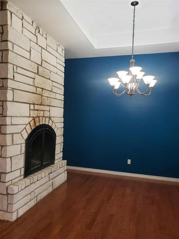 7336 E 136th Rd, Holdenville, OK 74848 - unfurnished living room with baseboards, a chandelier, and wood finished floors