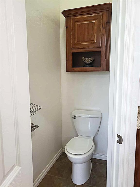 7336 E 136th Rd, Holdenville, OK 74848 - bathroom featuring baseboards, toilet, and tile patterned floors
