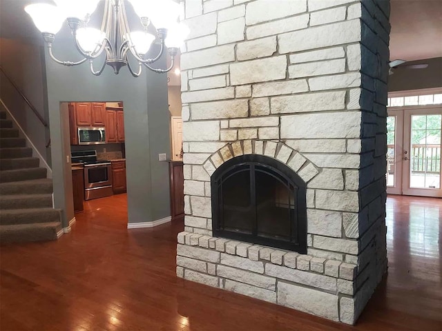 7336 E 136th Rd, Holdenville, OK 74848 - unfurnished living room featuring baseboards, stairway, dark wood finished floors, a chandelier, and a fireplace