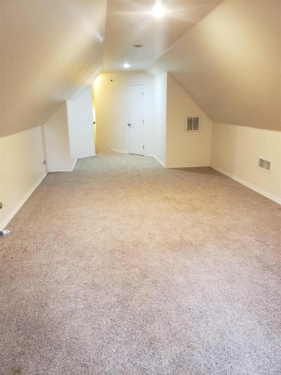 7336 E 136th Rd, Holdenville, OK 74848 - additional living space featuring vaulted ceiling, light colored carpet, and baseboards
