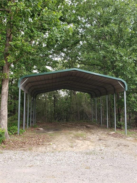 7336 E 136th Rd, Holdenville, OK 74848 - view of parking / parking lot featuring a detached carport and a wooded view