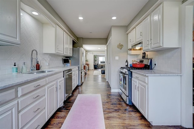 3104 NW 21st St, Oklahoma City, OK 73107 - kitchen with appliances with stainless steel finishes, under cabinet range hood, dark wood finished floors, white cabinetry, and recessed lighting