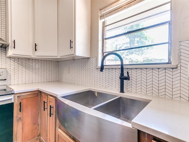 1400 Brookhaven Dr, Edmond, OK 73034 - kitchen featuring a sink, stainless steel electric stove, light countertops, white cabinetry, and tasteful backsplash