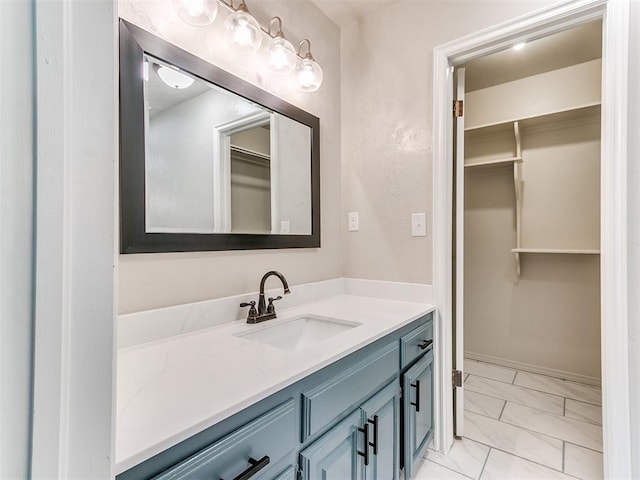1400 Brookhaven Dr, Edmond, OK 73034 - bathroom with marble look tiles, vanity, and a walk in closet