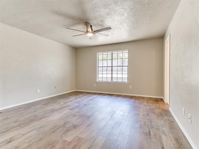 1400 Brookhaven Dr, Edmond, OK 73034 - empty room with a ceiling fan, wood finished floors, a textured ceiling, baseboards, and a textured wall