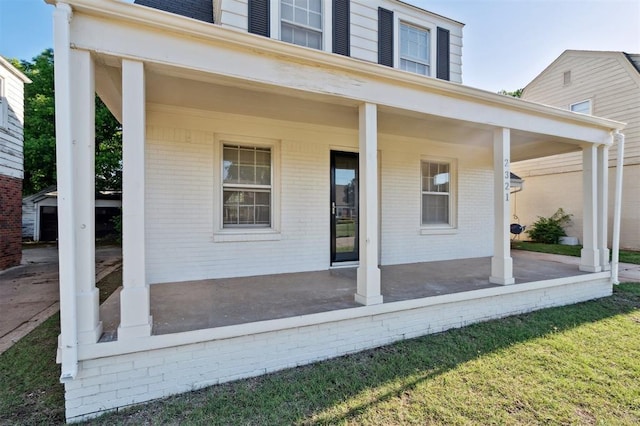 2321 NW 25th St, Oklahoma City, OK 73107 - view of exterior entry featuring covered porch and brick siding