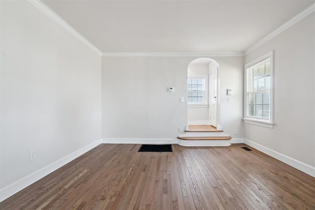 2321 NW 25th St, Oklahoma City, OK 73107 - unfurnished room featuring arched walkways, crown molding, wood finished floors, and baseboards