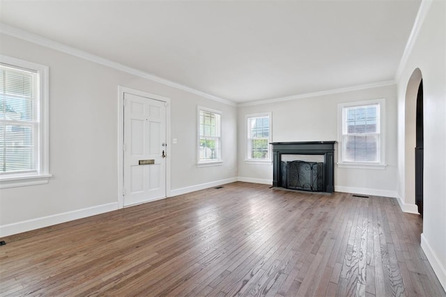 2321 NW 25th St, Oklahoma City, OK 73107 - unfurnished living room with hardwood / wood-style flooring, ornamental molding, arched walkways, baseboards, and a fireplace