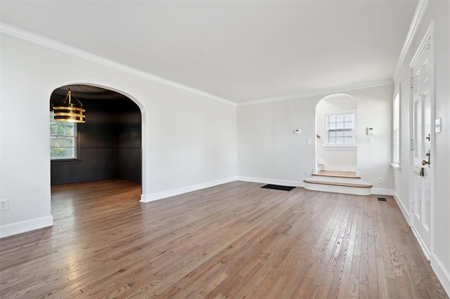 2321 NW 25th St, Oklahoma City, OK 73107 - unfurnished room featuring arched walkways, wood finished floors, plenty of natural light, and ornamental molding