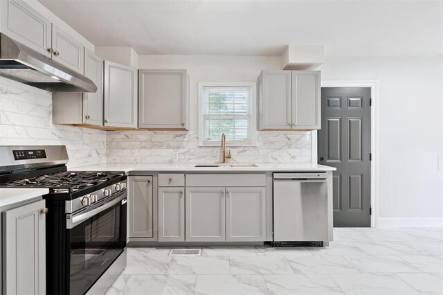 2321 NW 25th St, Oklahoma City, OK 73107 - kitchen with stainless steel appliances, a sink, under cabinet range hood, gray cabinets, and light marble finish flooring