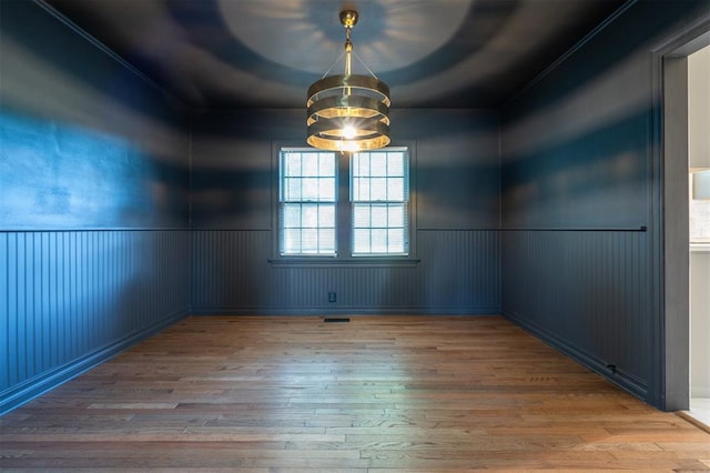 2321 NW 25th St, Oklahoma City, OK 73107 - unfurnished room featuring wood-type flooring, wainscoting, a chandelier, and ornamental molding
