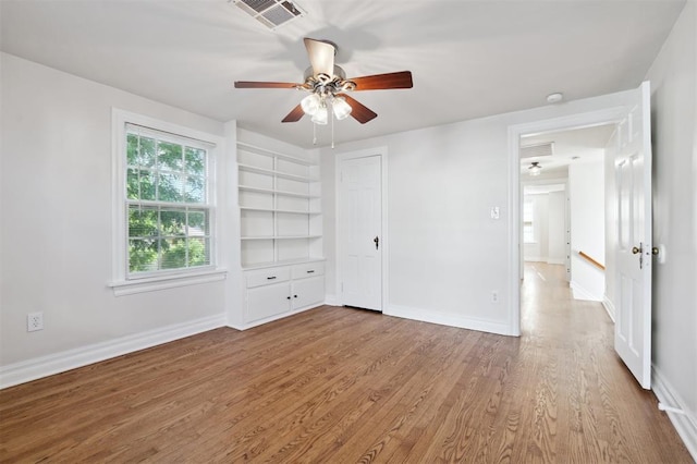 2321 NW 25th St, Oklahoma City, OK 73107 - unfurnished bedroom with wood finished floors, baseboards, a ceiling fan, and a closet