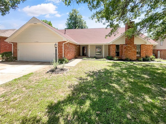 ranch-style home featuring an attached garage, brick siding, driveway, a front lawn, and a chimney