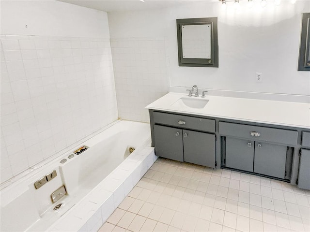 full bath featuring a whirlpool tub, vanity, and tile patterned floors