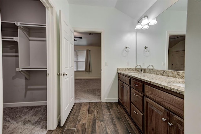 316 SW 4th Pl, Newcastle, OK 73065 - bathroom featuring lofted ceiling, double vanity, a spacious closet, baseboards, and wood finished floors
