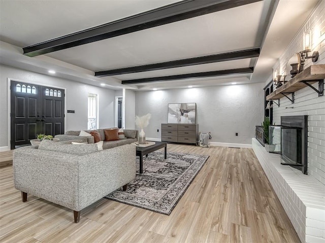 11008 Blue Sage Rd, Oklahoma City, OK 73120 - living area featuring light wood-style floors, beam ceiling, a fireplace, and baseboards