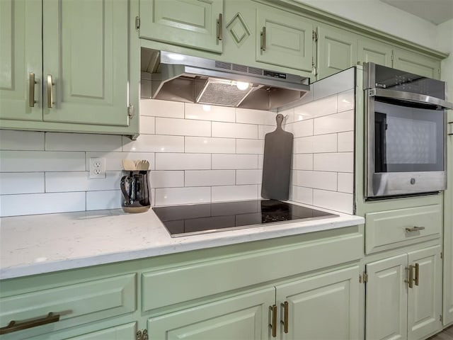 11008 Blue Sage Rd, Oklahoma City, OK 73120 - kitchen featuring under cabinet range hood, stainless steel oven, backsplash, black electric stovetop, and green cabinets